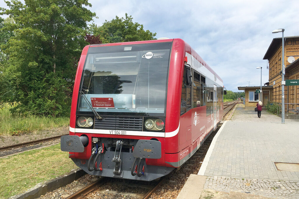 Ein Triebwagen steht an einem Bahnsteig.