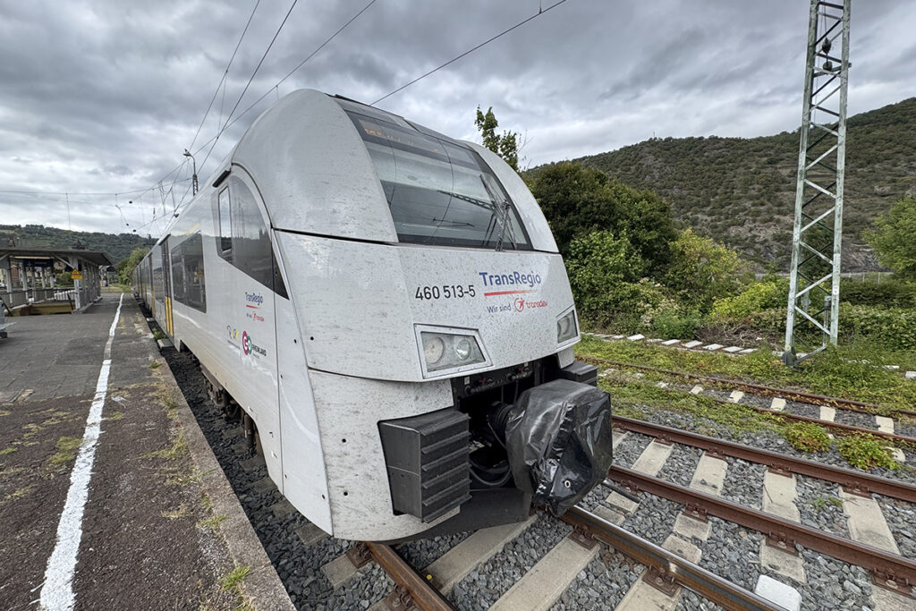 Ein Zug hält an einem Bahnsteig.