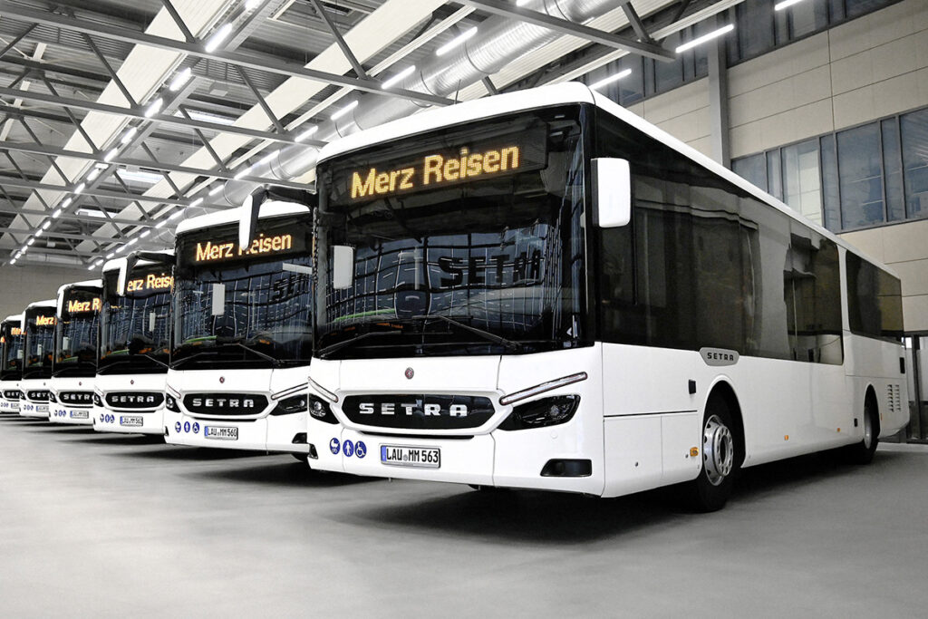 Mehrere Busse stehen in einer Halle nebeneinander.