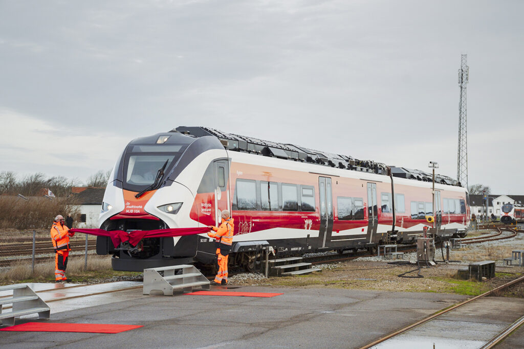 Vor einem Zug im Betriebswerk stehen zwei Personen.