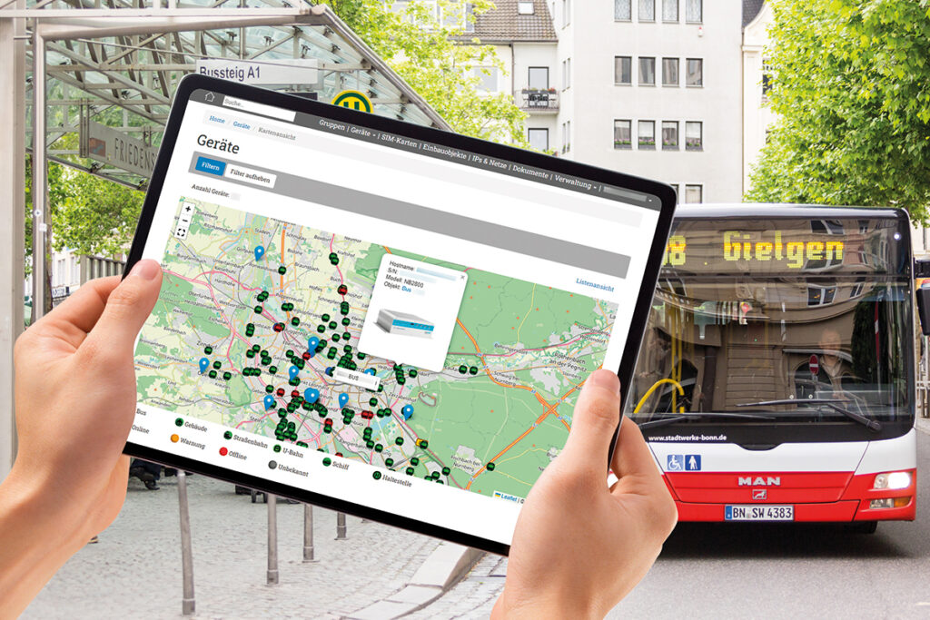 Im Vordergrund halten zwei Hände in Tablet, hinten steht ein Bus.