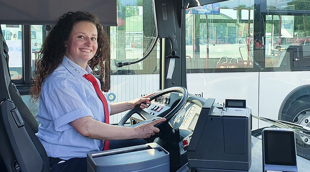 Eine Frau sitzt am Steuer eines Busses.