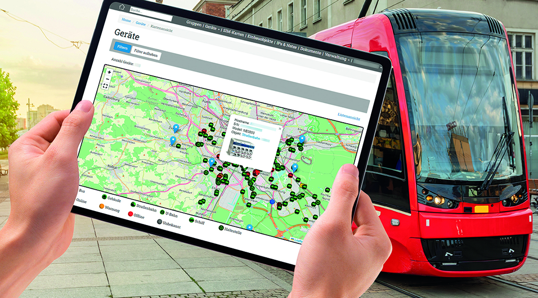Hände halten ein Tablet, dahinter steht eine Straßenbahn.