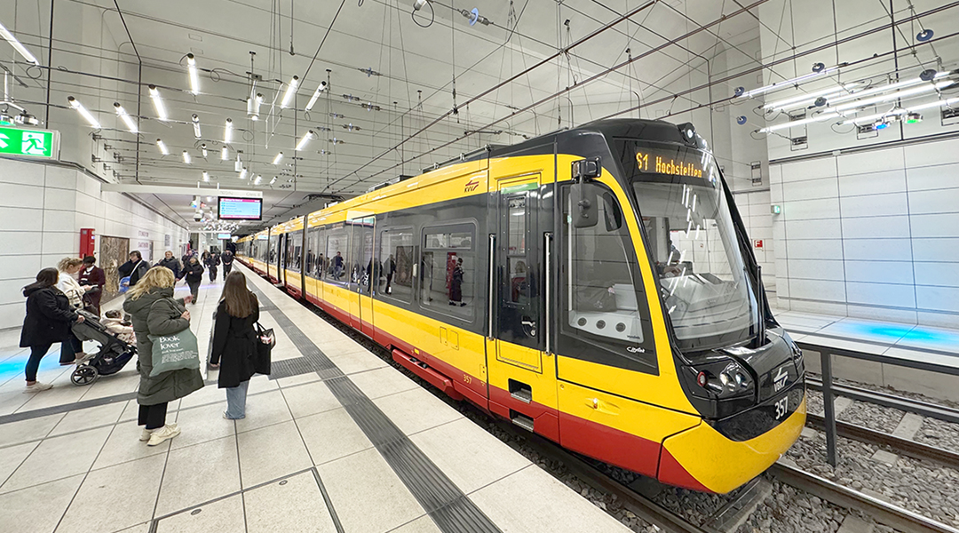 Eine Straßenbahn steht in einer Tunnelhaltestelle an einem Bahnsteig.