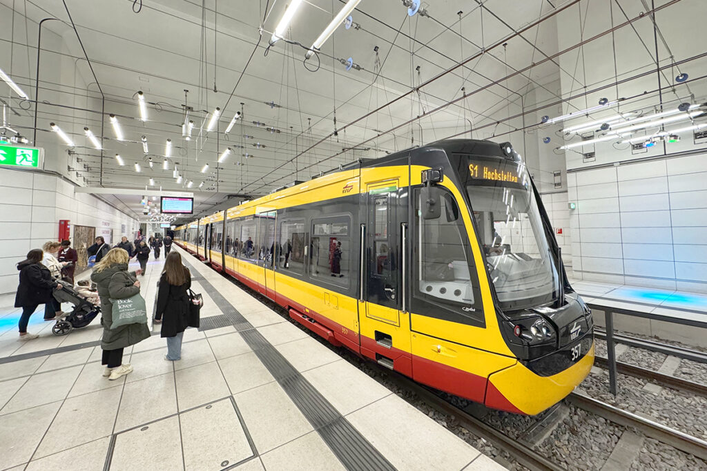 Eine Straßenbahn steht in einer Tunnelhaltestelle an einem Bahnsteig.