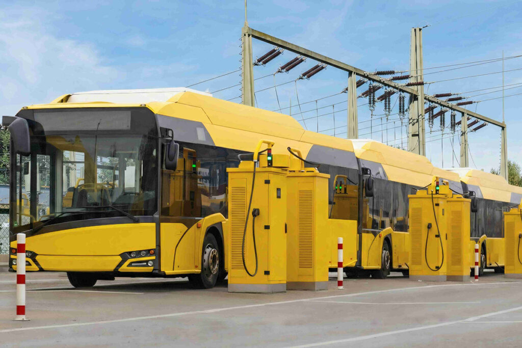 Elektrobusse stehen hintereinander an einer Ladestation.