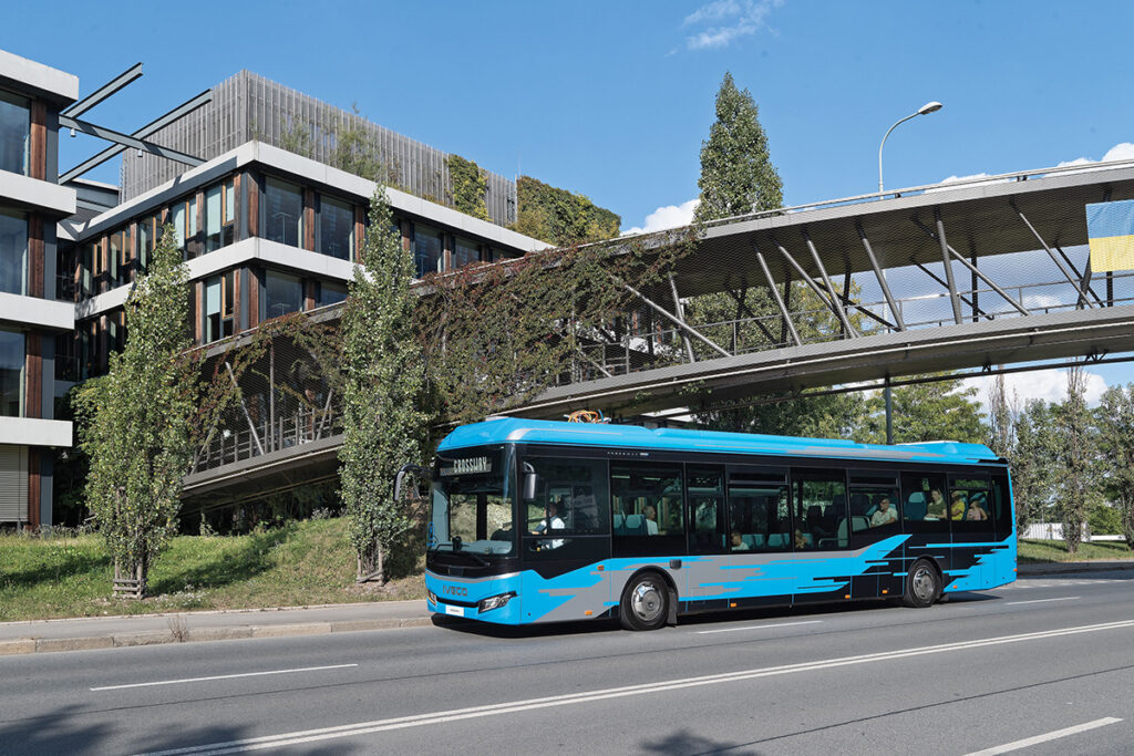 Ein BUs fährt unter einer Brücke hindurch.
