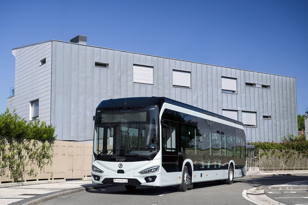Ein Elektrobus steht vor einem Gebäude.