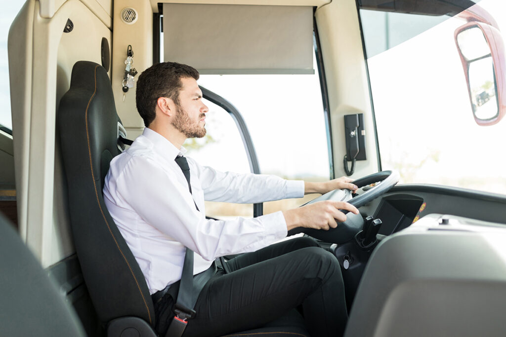 Eine Person sitzt am Steuer eines Busses.