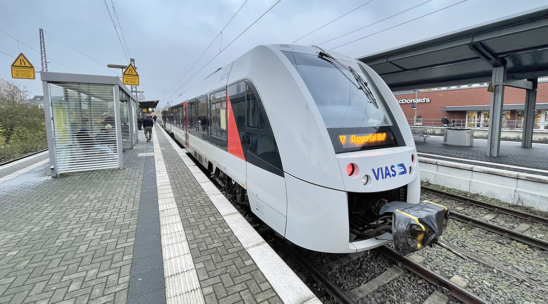 Ein Triebzug steht an einem Bahnsteig.