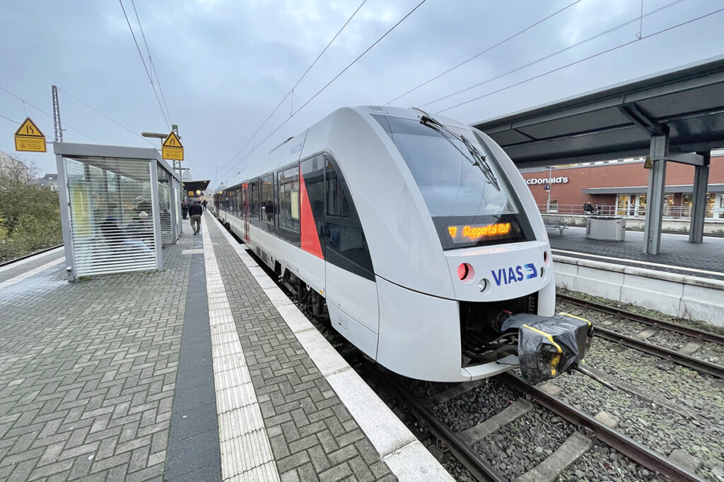 Ein Triebzug steht an einem Bahnsteig.