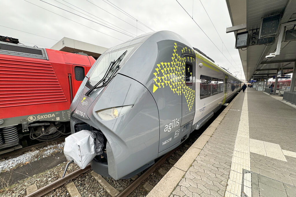 Ein Triebzug steht an einem Bahnsteig.