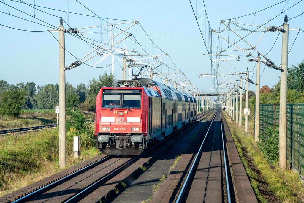 Ein Zug fährt auf einer zweigleisigen Strecke.