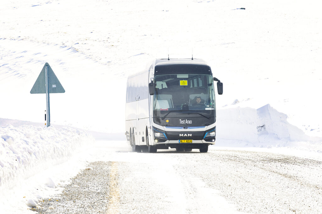 Ein Bus fährt auf einer verschneiten Straße.