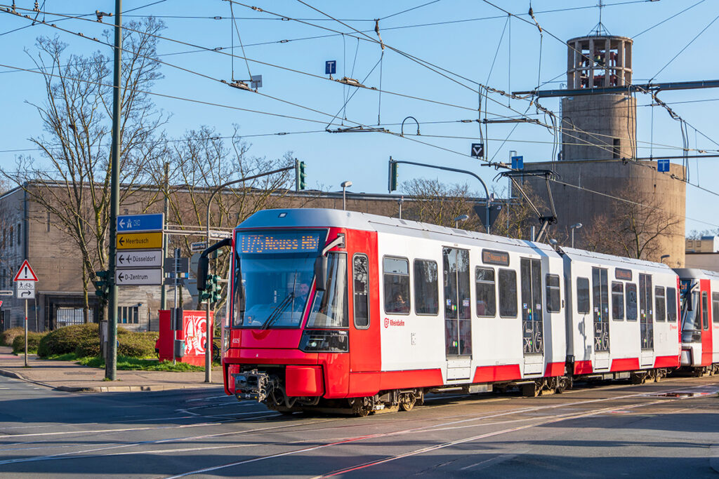 Eine Stadtbahn fährt auf einer Straße.