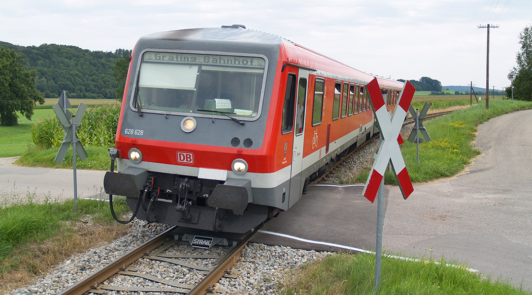 Ein Zug fährt über einen Bahnübergang.