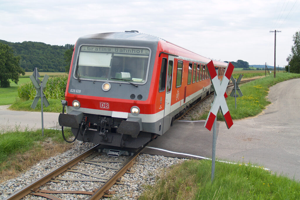 Ein Zug fährt über einen Bahnübergang.