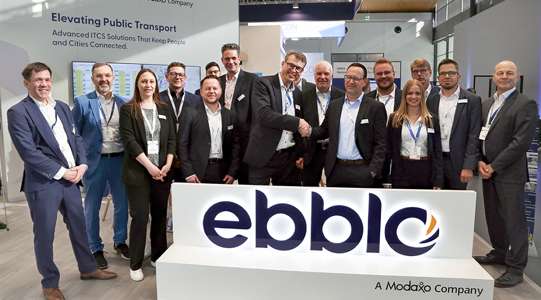 Zahlreiche Personen stehen hinter einem Schild mit der Aufschrift ebblo.