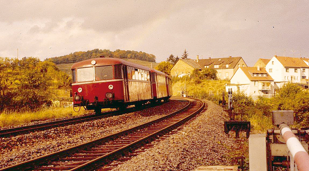 Ein Schienenbus fährt auf einer zweigleisigen Strecke.