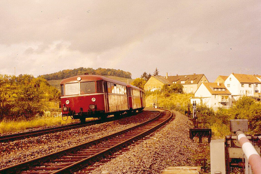 Ein Schienenbus fährt auf einer zweigleisigen Strecke.