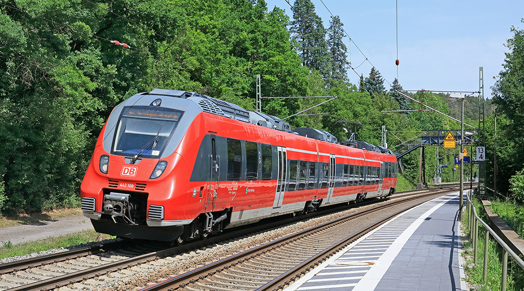 Ein S-Bahn-Triebzug fährt auf einer zweigleisigen Strecke durch den Wald.