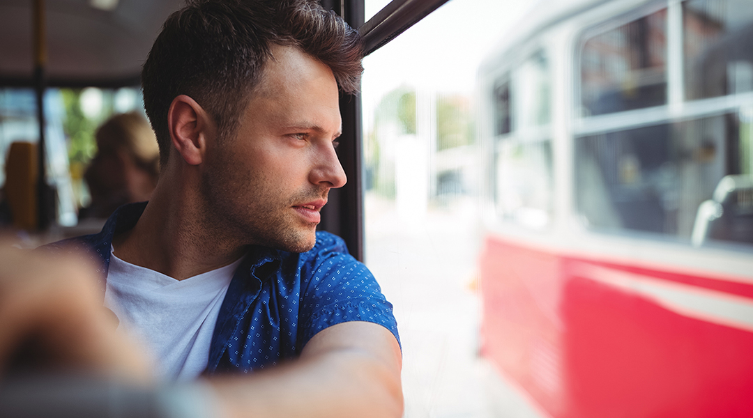 Eine Person schaut aus dem Fenster eines Busses.
