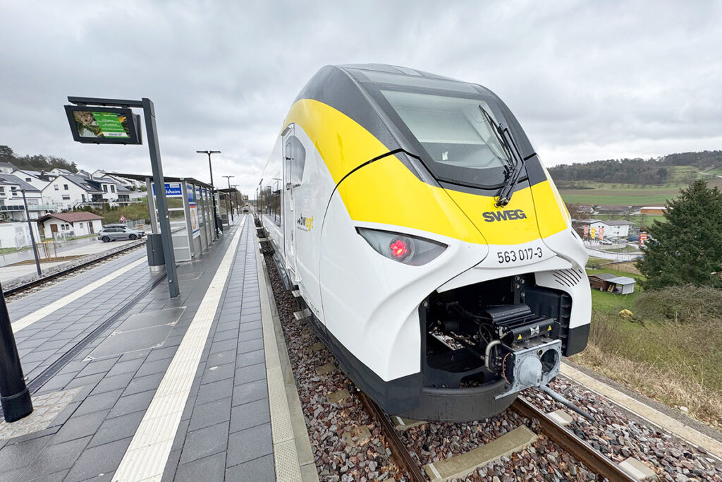 Ein Zug hält an einem Bahnsteig.