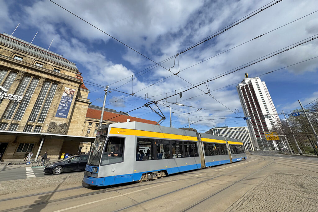 Eine Straßenbahn fährt vor Gebäuden entlang.