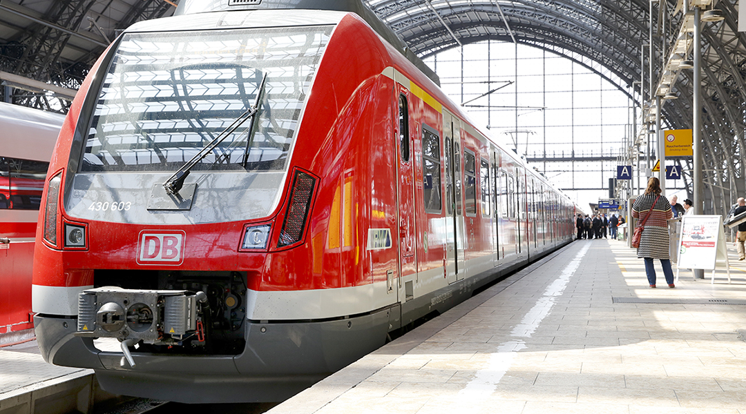 Eine S-Bahn steht in einer Bahnhofshalle an einem Bahnsteig.