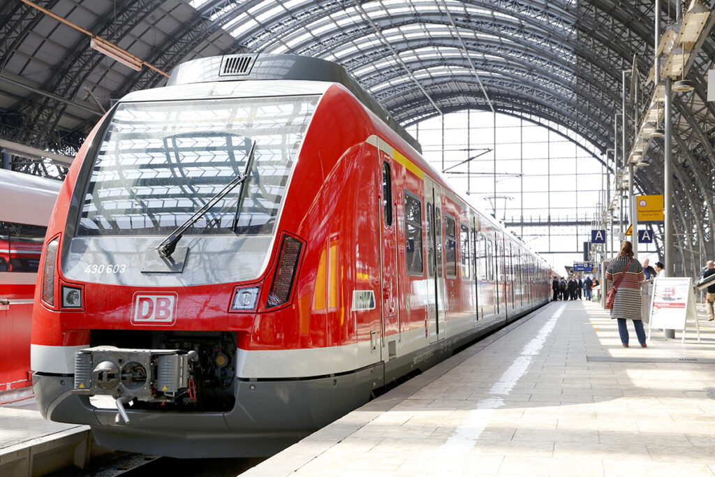 Eine S-Bahn steht in einer Bahnhofshalle an einem Bahnsteig.