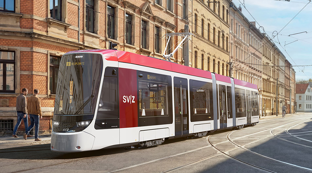 Visualisierung einer Straßenbahn auf einer Straße vor Häusern.