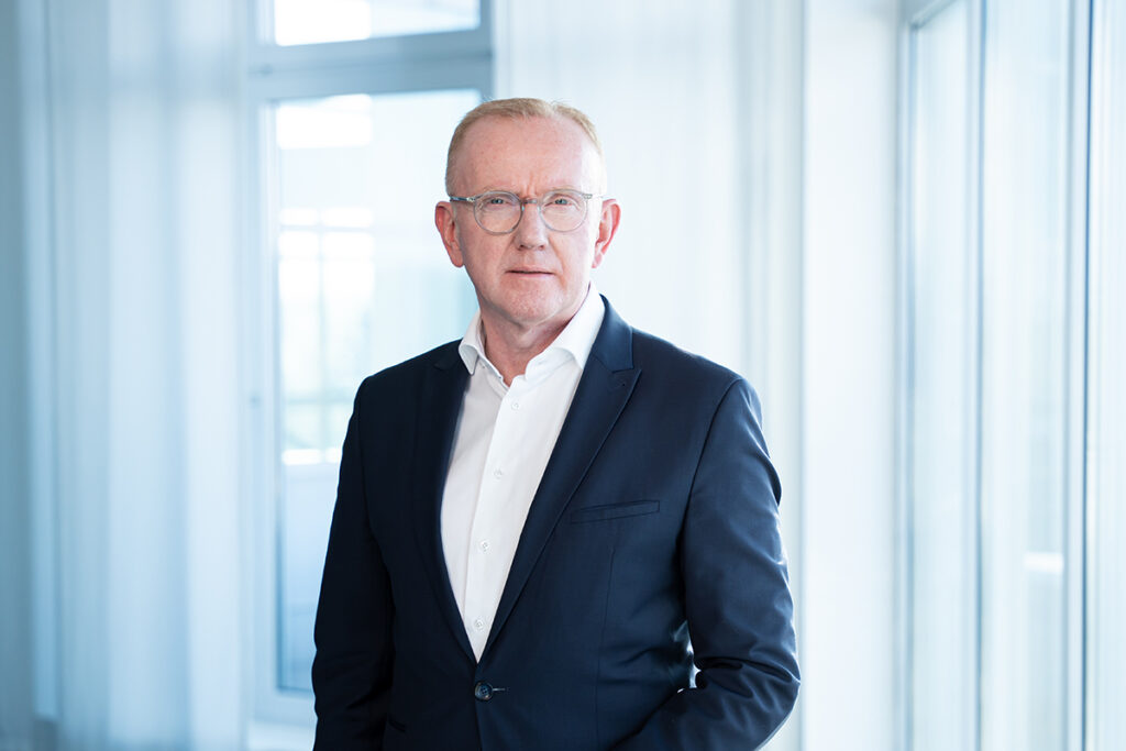 Eine Person steht vor einem Fenster.