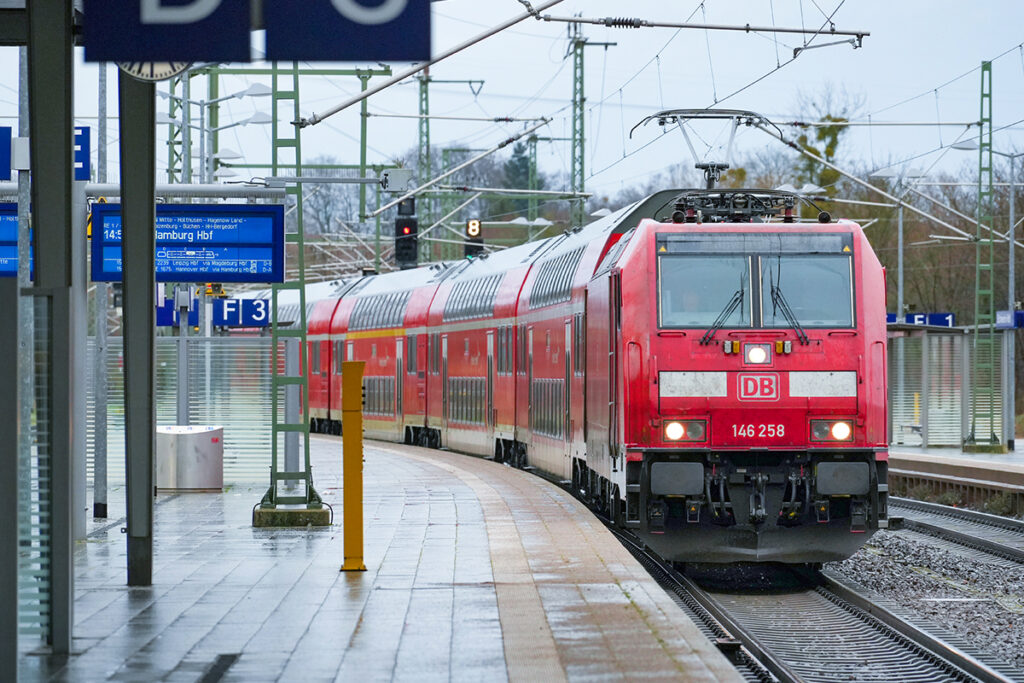 Ein Zug mit Doppelstockwagen fährt an einem Bahnsteig ein.