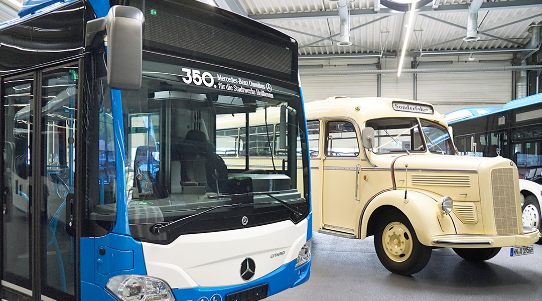 Ein neuer Linienbus steht neben einem historischen Bus.