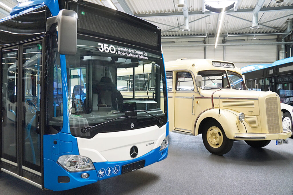 Ein neuer Linienbus steht neben einem historischen Bus.