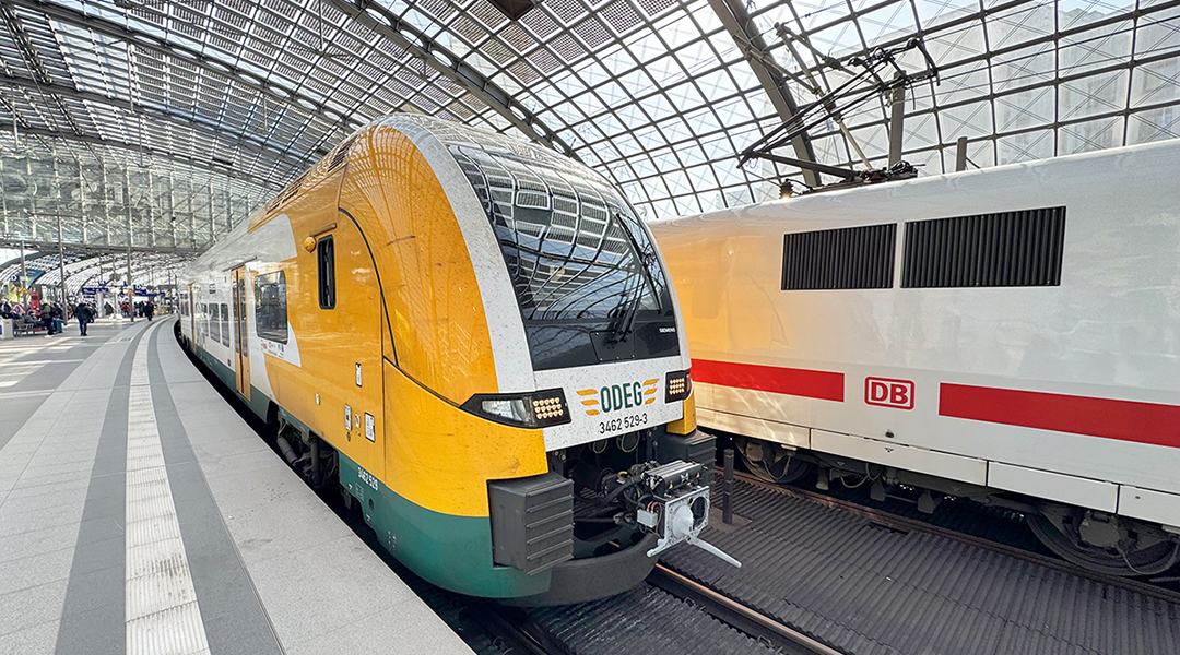 Ein Zug hält in einer Bahnhofshalle an einem Bahnsteig.