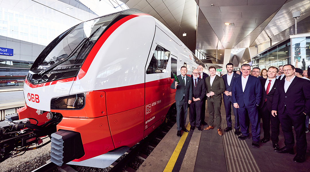 An einem Bahnsteig mit vielen Menschen steht ein Doppeltockzug.