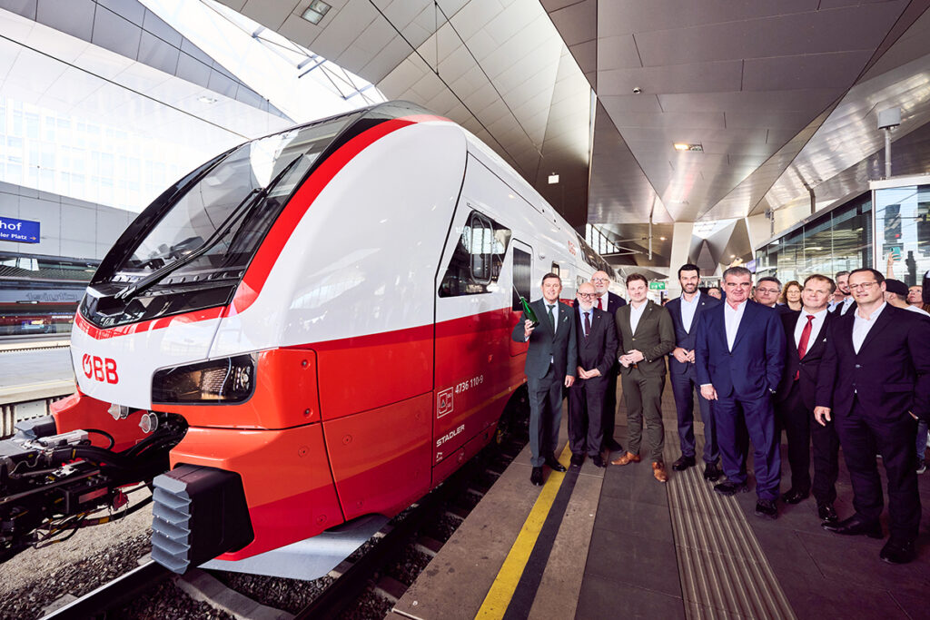 An einem Bahnsteig mit vielen Menschen steht ein Doppeltockzug.