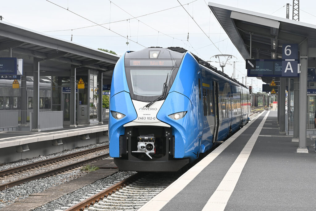 Ein Triebzug steht an einem Bahnsteig.