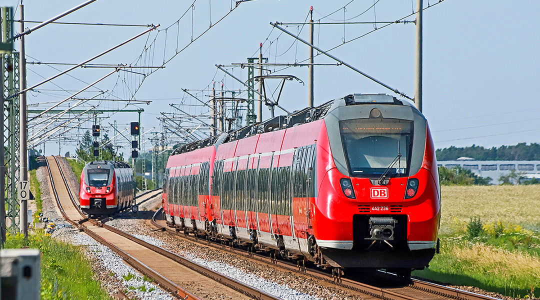 Zwei S-Bahn-Züge fahren auf einer zweigleisigen Strecke.