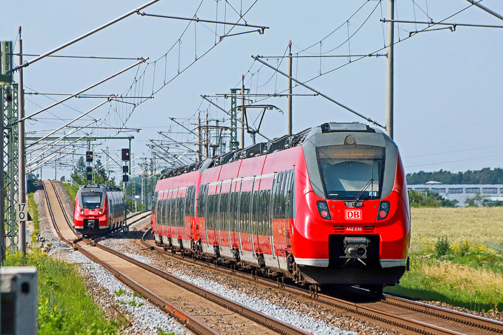 Zwei S-Bahn-Züge fahren auf einer zweigleisigen Strecke.