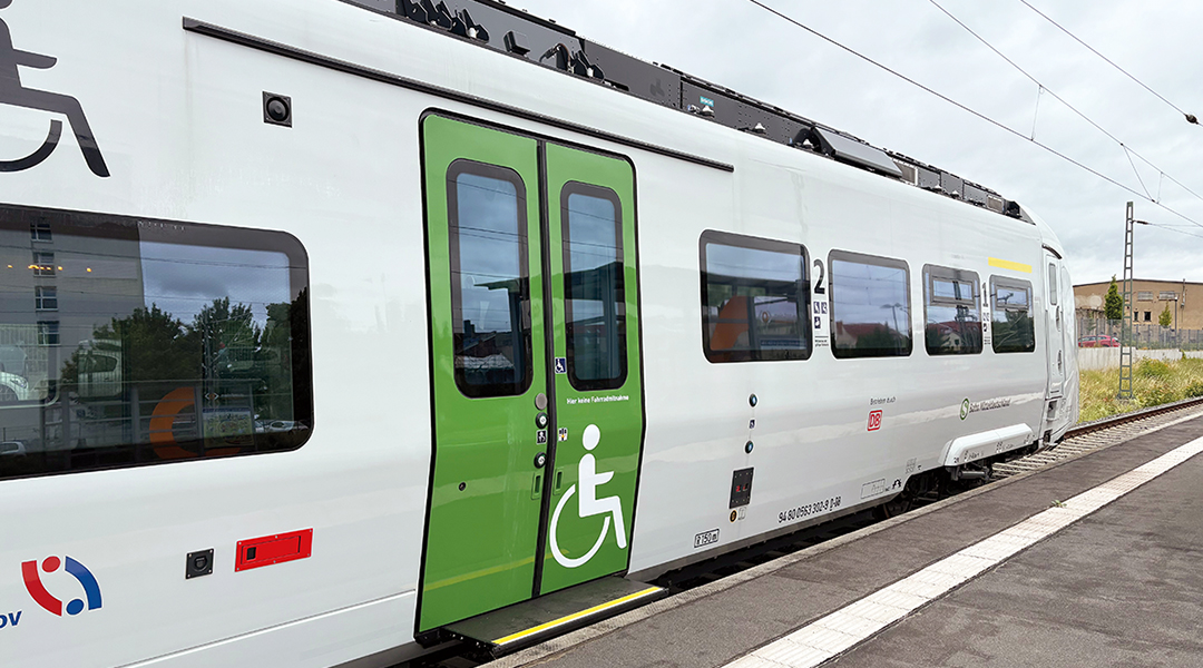 Ein Akkuzug mit barrierefreiem Einstieg steht an einem Bahnsteig.