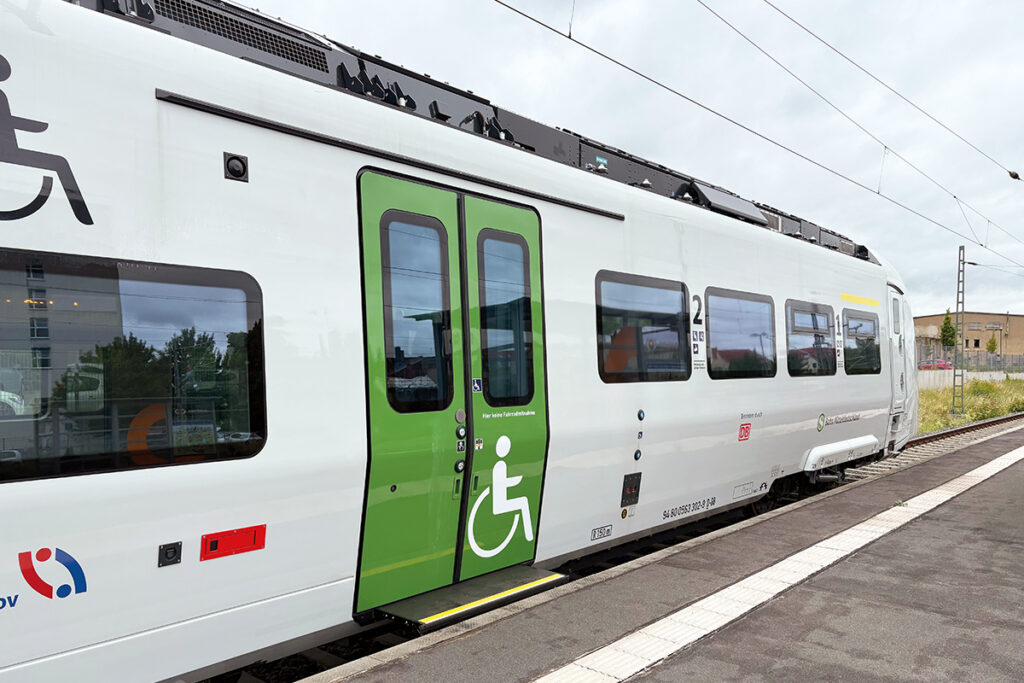 Ein Akkuzug mit barrierefreiem Einstieg steht an einem Bahnsteig.