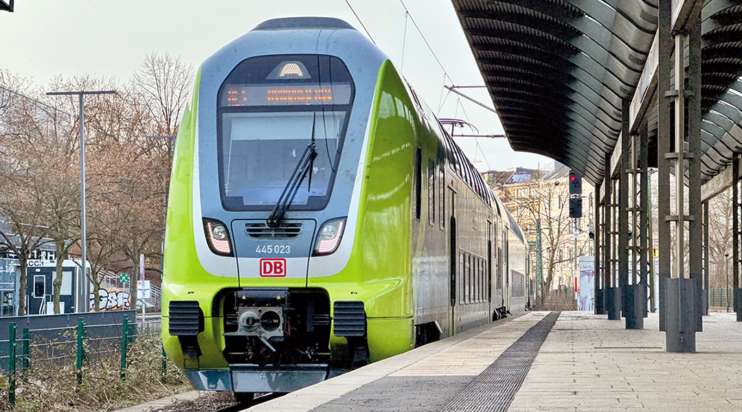 Ein Triebzug von DB Regio fährt an einem überdachten Bahnsteig ein.