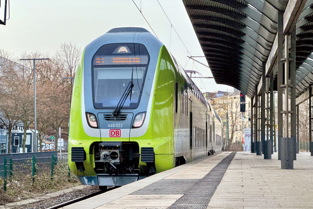Ein Triebzug von DB Regio fährt an einem überdachten Bahnsteig ein.