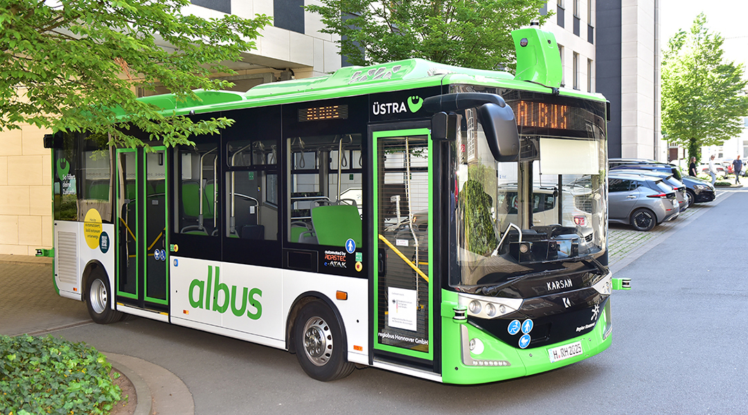 Ein autonomer Bus steht vor einem Gebäude.