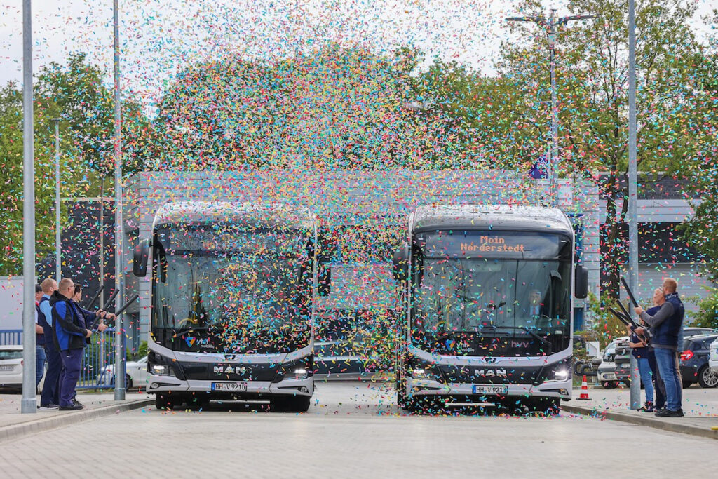 Auf zwei Elektrobusse regnet Konfetti herab.