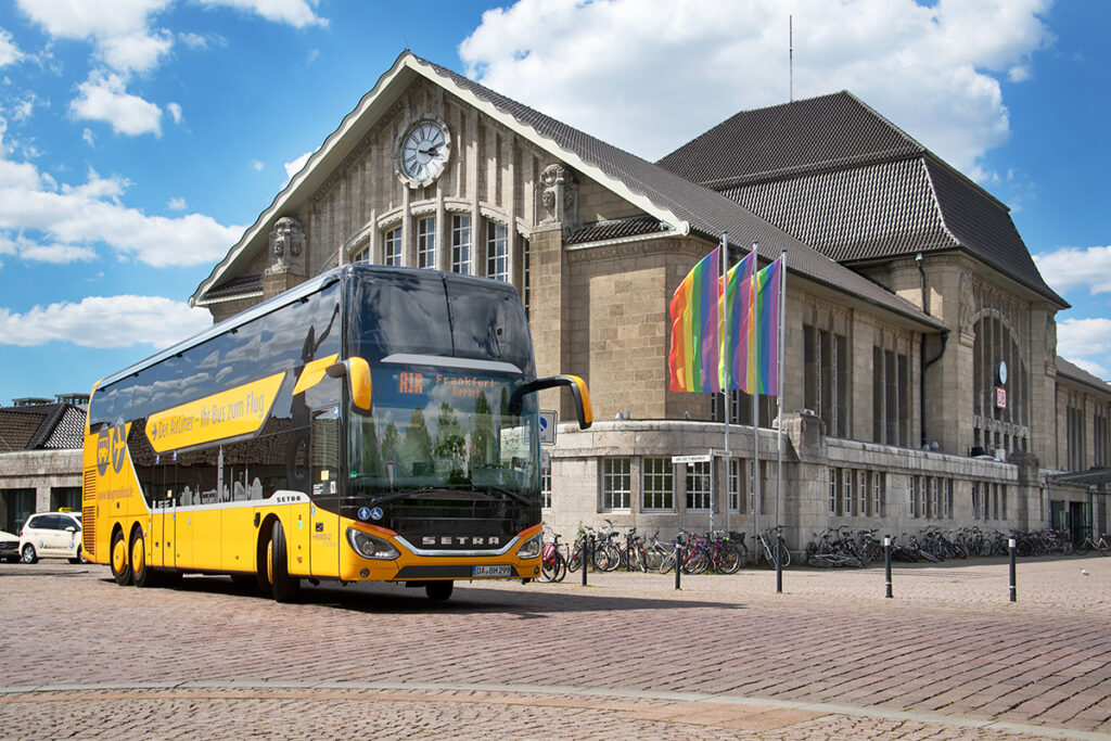 Ein Doppelstockbus steht vor dem Bahnhofsgebäude in Darmstadt.