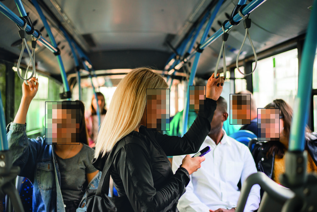 Mehrere Personen mit verpixelten Gesichtern in einem Bus.