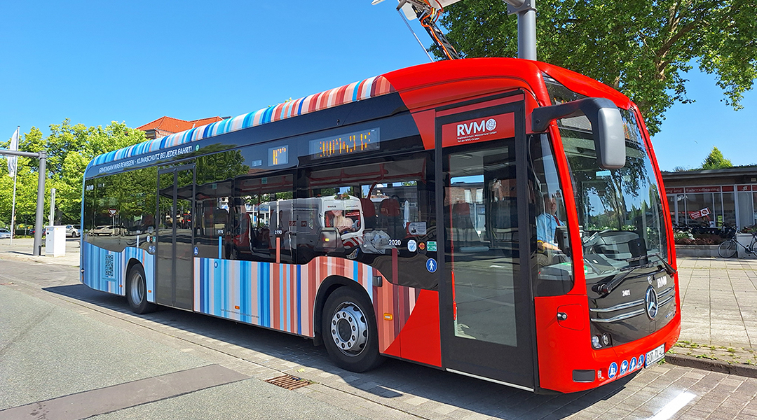 Ein Elektrobus steht unter einem Lademast.